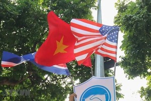 National flags of the DPRK, the US and Vietnam attached to a plaque with a friendship symbol of handshake are decorating many streets downtown Hanoi. (Photo: VNA)