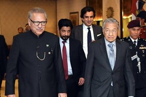 Prime Minister Tun Dr Mahathir Mohamad walks with Pakistan President Dr Arif Alivi (L) during a courtesy call at the President’s House on March 23, 2019. (Photo: Bernama)