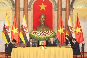 Party General Secretary and President Nguyen Phu Trong (right) and Brunei's Sultan Haji Hassanal Bolkiah witnessed the signing of a memorandum of understanding (MoU) on the use of a hotline to deal with illegal, unreported, and unregulated (IUU) fishing b