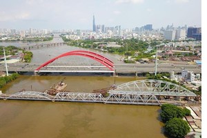 New Binh Loi Bridge is under construction in HCMC with the height from the water surface to the bridge much higher than the old adjacent one (Photo: SGGP)