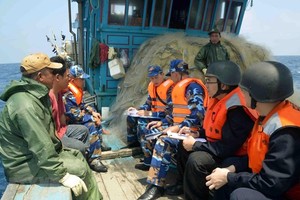 Vietnamese, Chinese coast guards inspect a Vietnamese fishing vessel in the Gulf of Tonkin (Photo: VNA)