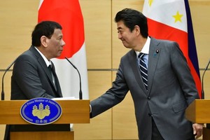 Philippine President Rodrigo Duterte (L) greets Prime Minister Shinzo Abe during a joint press statement in Tokyo on May 31 (Source: Reuters)