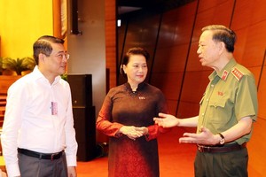 NA Chairwoman Nguyen Thi Kim Ngan (centre) and Minister of Public Security To Lam (R) discuss before the session begins (Photo: VNA)