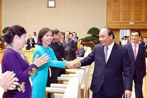 Prime Minister Nguyen Xuan Phuc (R) greets representatives from the Vietnam Private Business Association at the event in Hanoi on June 17 (Photo: VNA)
