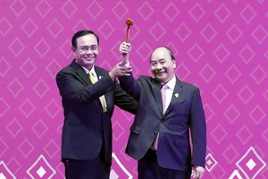 Thai Prime Minister Prayut Chan-o-cha (L) hands the chairmanship hammer to his Vietnamese counterpart Nguyen Xuan Phuc at the ceremony in Bangkok on November 4 evening (Photo: VNA)