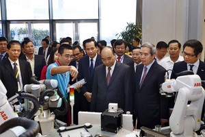 Prime Minister Nguyen Xuan Phuc (front, third, right) visits an exhibition on the sidelines of the forum on vocational training in Hanoi on November 16 (Photo: VNA)