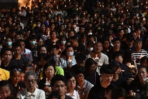 People take part in a candle-lit vigil for victims following the mass shooting in Nakhon Ratchasima (Source: AFP)