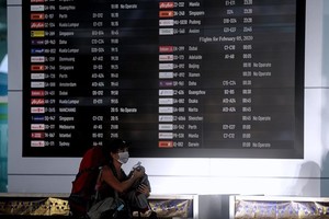 A passenger walks near the flight information board at the departure gate of I Gusti Ngurah Rai International Airport in Bali, Indonesia (Photo: Antara)