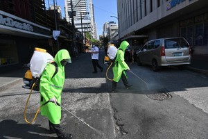 Workers disinfect an area in Manila, the Philippines, on March 19 to help curb the spread of COVID-19 (Photo: AFP/VNA)