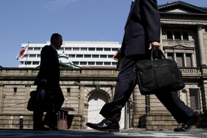 Japanese office workers walk on a street in front of the Bank of Japan headquarters in Tokyo. (Photo: Reuters)