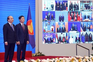Vietnamese Prime Minister Nguyen Xuan Phuc (L) and Minister of Industry and Trade Tran Tuan Anh, together with leaders of other RCEP member countries, witness the pact signing via videoconference on November 15 (Photo: VNA)
