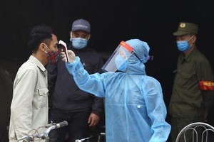 A man has his body temperature checked. (Photo: VNA)