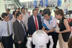 HCMC leaders look at AI products displayed at an exhibition held on the "Day for AI and IT Enterprises" event recently in HCMC. (Photo: VNA/VNS)