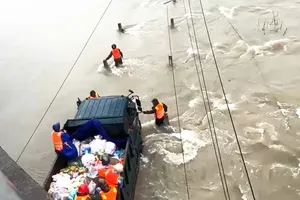 The rescue force is trying to evacuate a newborn and the mother from the flood zone in West Nha Trang of Khanh Hoa Province (Photo: SGGP)