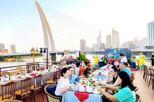 Tourists join a sunset cruise on the Bach Dang River as part of Ho Chi Minh City's night-time economy and river tourism initiatives.