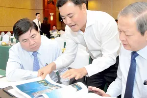 Chủ tịch UBND TPHCM Nguyễn Thành Phong xem một phác thảo công trình xây dựng tại hội nghị                      Ảnh: CAO THĂNG