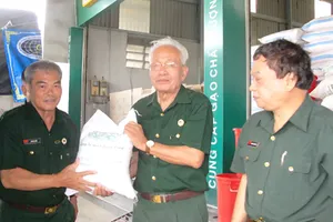 Trung tướng Lê Thành Tâm (phải) chuyển gạo lên xe đưa đi cứu trợ  đồng bào các tỉnh miền Trung bị ảnh hưởng cơn bão số 10 vừa qua