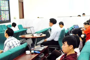 Nhà đầu tư theo dõi giá cổ phiếu tại một công ty chứng khoán                    Ảnh: Cao Thăng