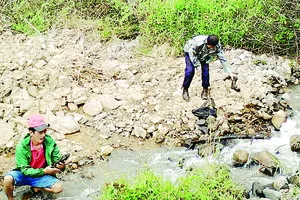 Nghệ nhân Nguyễn Phi Hải (áo đỏ) trong chuyến “săn đá” tại bãi đá lộ thiên dưới chân núi Voi 