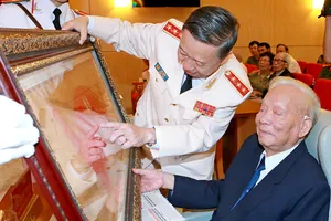 Thượng tướng  Tô Lâm, Ủy viên Bộ Chính trị,  Bí thư Đảng ủy Công an Trung ương, Bộ trưởng Bộ Công an trao tặng Cuốn thư ghi nhận công lao, đóng góp cho nguyên Ủy viên Bộ Chính trị, nguyên Chủ tịch nước Lê Đức Anh trong cuộc Gặp mặt truyền thống các thế hệ