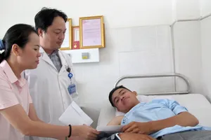 Đại diện Báo SGGP thăm và trao tiền bạn đọc hỗ trợ anh Đinh Phú Quý.  Ảnh: VIỆT NGA