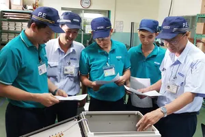 Anh Trịnh Minh Đức (bìa phải) cùng các đồng nghiệp thảo luận và thiết kế, chế tạo thành công máy kiểm tra dây điện 