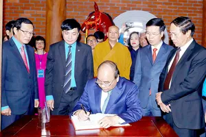 Thủ tướng Nguyễn Xuân Phúc ghi sổ lưu niệm tại Nhà tưởng niệm đồng chí Nguyễn Đức Cảnh.  Ảnh: TTXVN