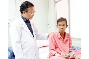 Bác sĩ Nguyễn Thái An thăm hỏi sức khỏe một bệnh nhân người Campuchia.  Ảnh: NVCC