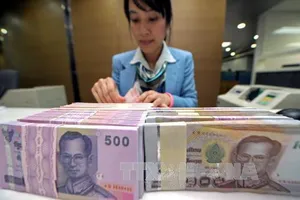 Kiểm tiền baht của Thái Lan tại ngân hàng Krung Thai ở Bangkok. Ảnh: AFP/TTXVN