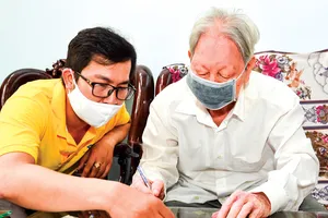 Bưu tá đến tận nhà  chi trả chế độ ưu đãi  người có công  với cách mạng tại quận 1, TPHCM. Ảnh: VIỆT DŨNG