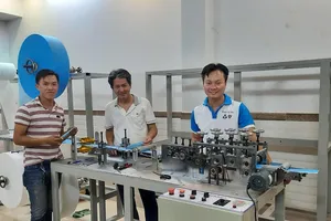 PGS.TS Nguyễn Hữu Lộc (giữa) và TS Nguyễn Thanh Hải (phải) bên máy tạo thân khẩu trang y tế.
