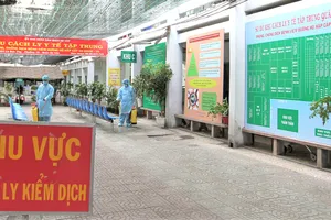 Ở mỗi khu cách ly, nhân viên y tế dự phòng luôn túc trực  phun tiêu độc khử trùng. Ảnh: HOÀNG HÙNG