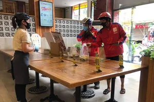 Một quán ăn trên địa bàn quận 8 kê bàn khoảng cách 2m giữa khách và nhân viên  nhằm phục vụ cho những món mang về. Ảnh: HOÀNG HÙNG