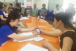 Nhân viên EVNHCMC hướng dẫn khách hàng cài đặt và sử dụng app EVNHCMC CSKH.  Ảnh tư liệu