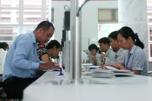 Cán bộ UBND quận 1 (TPHCM, bìa phải) giải quyết hồ sơ cho người dân