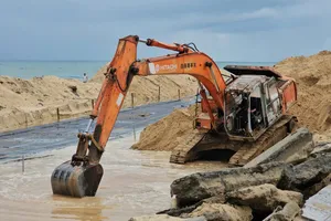 Máy móc thi công kè mềm nhằm ngăn chặn tình trạng sạt lở, nguy cơ mở cửa biển mới Thuận An