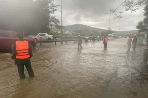 Lực lượng chức năng ứng trực hướng dẫn người và phương tiện lưu thông qua đoạn Quốc lộ 1A bị ngập