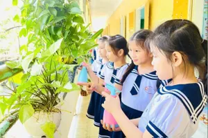 Học sinh Trường Tiểu học Lê Lợi (TP Huế) tưới cây ở các hành lang lớp học