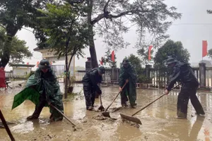 Bộ đội Biên phòng hỗ trợ Trường THCS Hương Thọ (TP Huế) thu dọn bùn non ứ đọng tại sân trường khi lũ rút