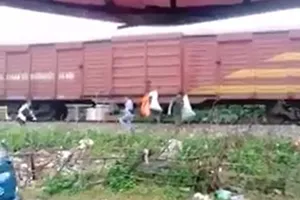 Một số người dân treo các bao rác thải lên thành toa tàu hỏa (Ảnh cắt từ clip trên facebook)