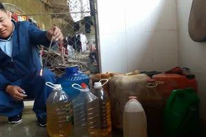 Dùng vật dụng nhúng vào nước giếng nhiễm dầu và châm lửa đốt cháy