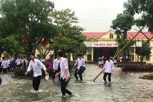 Nhiều em học sinh lội nước đến trường dự lễ khai giảng