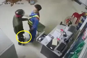 Đối tượng cầm dao khống chế nhân viên cửa hàng xăng dầu. Ảnh cắt từ clip