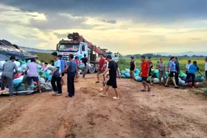 Người dân giúp đỡ tài xế bốc xếp các bao tải hàng sau tai nạn lật bên cao tốc 