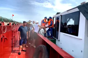 Cán bộ, chiến sĩ Hải đội 102 tiếp nhận cha con anh Nguyễn T.T., từ tàu hàng VINASHIN 555 để đưa vào bờ 