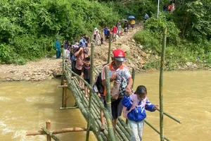 Học sinh được lực lượng chức năng hỗ trợ qua cầu tạm để kịp đến trường trong buổi học đầu tuần