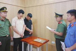 Cơ quan An ninh điều tra Công an tỉnh Hà Tĩnh tống đạt quyết định khởi tố bị can, thi hành lệnh tạm giam đối với Đặng Hoàng Lợi và Đặng Hùng Vương. Ảnh: BÙI HẢI