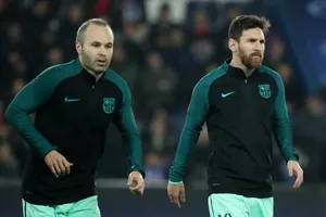 Lionel Messi (phải) và Andres Iniesta trên sân tập.