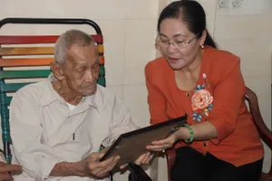 Đồng chí Nguyễn Thị Lệ, Phó Bí thư Thành ủy, Chủ tịch HĐND TPHCM trao di ảnh cho ba của liệt sĩ Nguyễn Ngọc Khanh. Ảnh: QUANG HUY