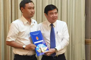 Đồng chí Nguyễn Thành Phong trao quyết định và chúc mừng đồng chí Huỳnh Thanh Nhân. Ảnh: THÁI PHƯƠNG   ​